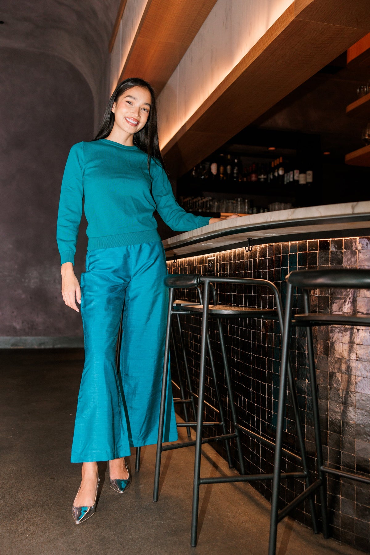 Model wearing Livro Paloma Pant in teal, lifestyle front view.