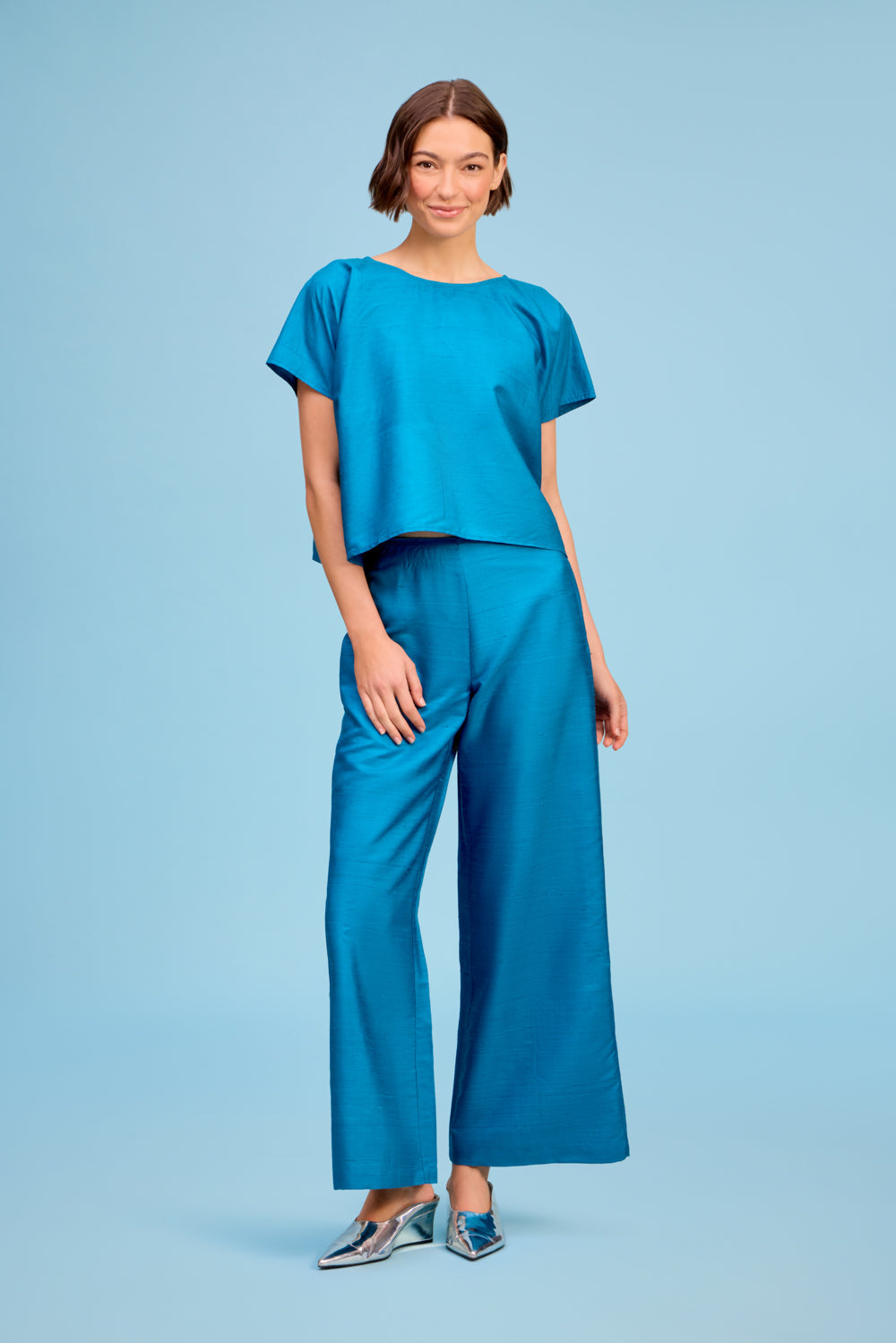 Model wearing Livro Paloma Pant in teal, front view.