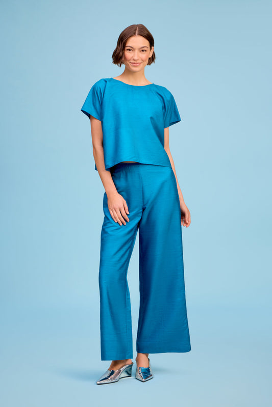 Model wearing Livro Paloma Pant in teal, front view.