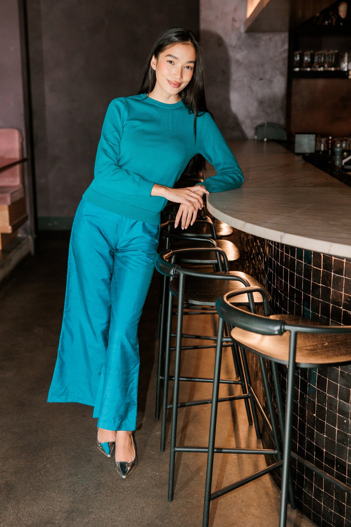 Model wearing Livro Paloma Pant in teal, lifestyle view.